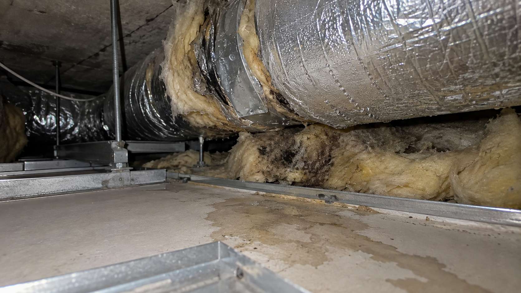 Condensation around an AC duct wetting insulation above a ceiling in a UAE home