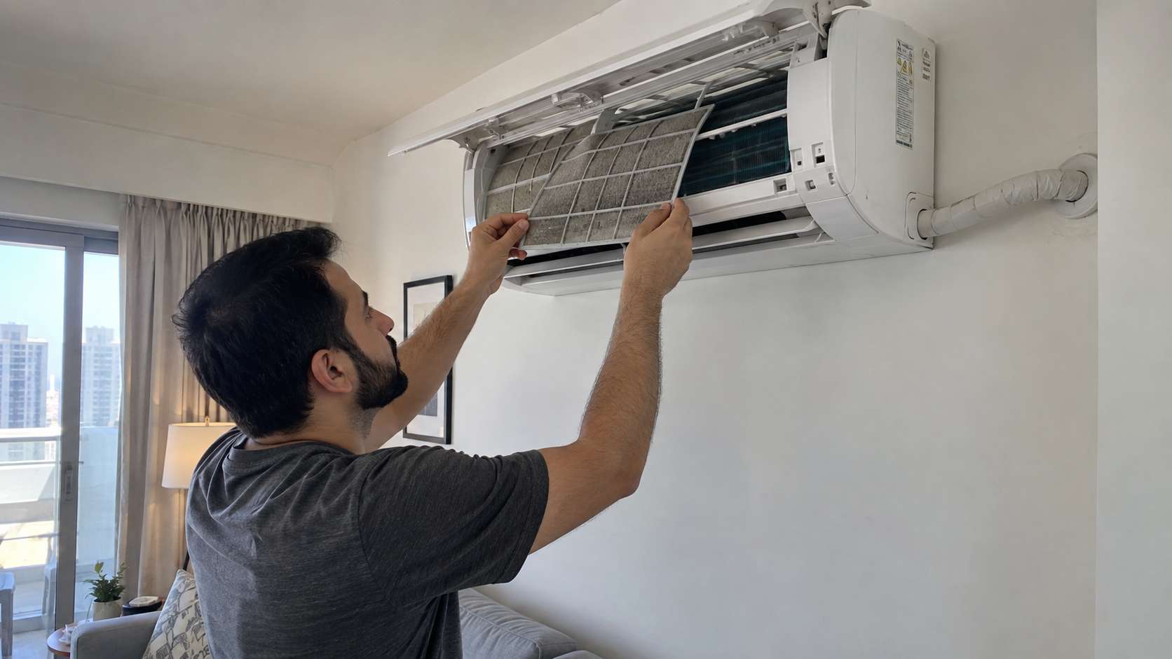 Homeowner checking a split AC filter and drainage system to help prevent mold in a UAE home