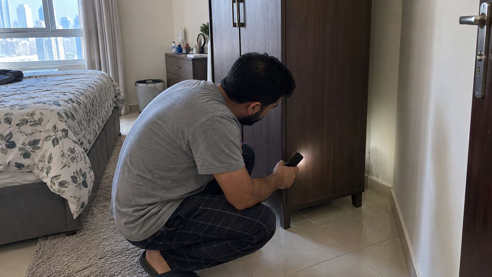 UAE homeowner checking behind a wardrobe for hidden moisture and airflow problems