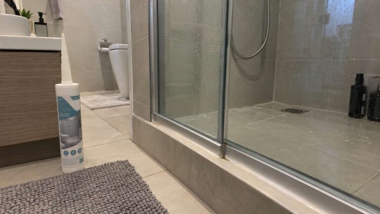 Sanitary silicone sealant beside a shower joint in a UAE bathroom with minor mold discoloration