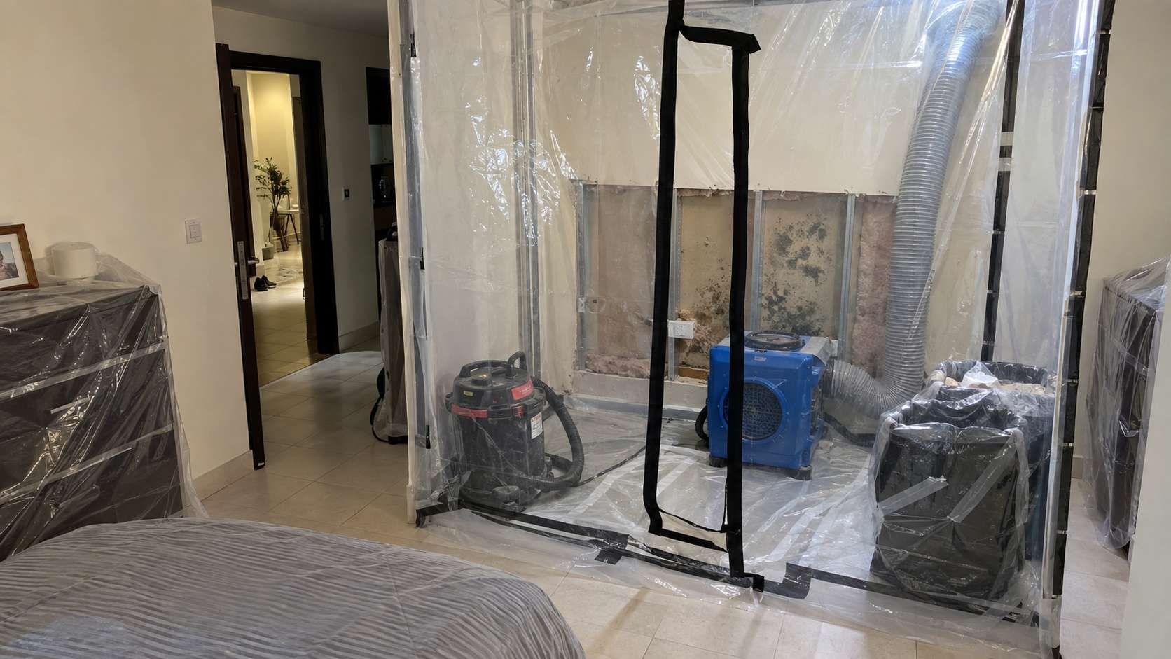 Plastic containment and HEPA equipment prepared for moldy drywall removal in a UAE apartment