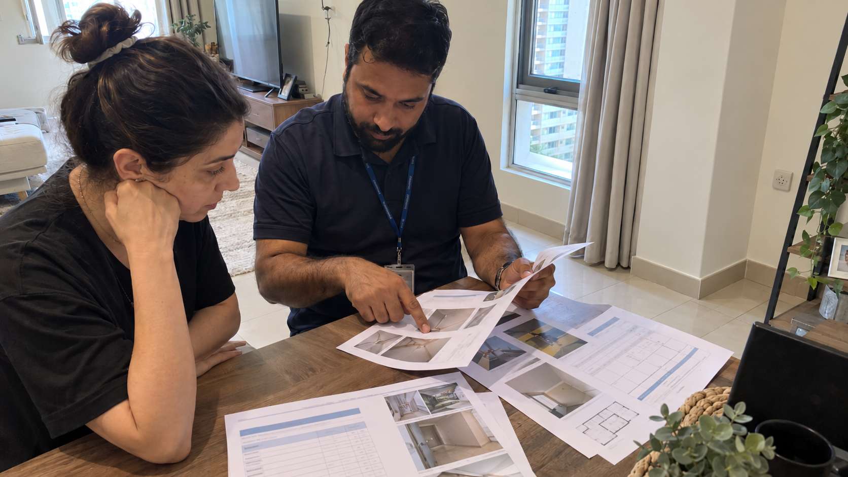 Buyer and inspector reviewing mold remediation records inside a restored residential property.