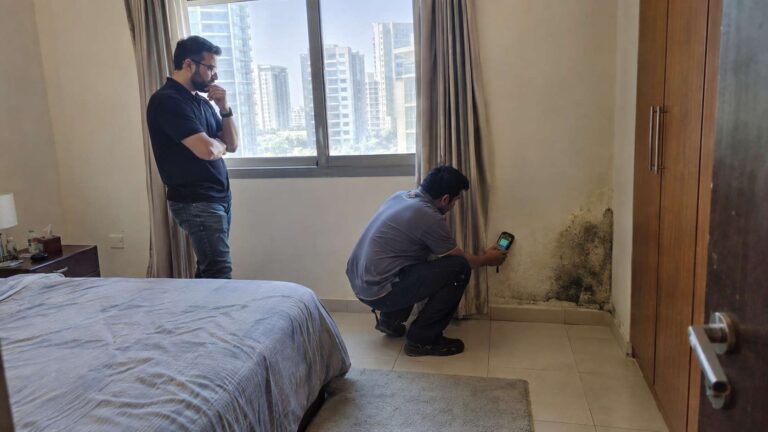 Property investor and inspector assessing localized mold and moisture damage inside a home.