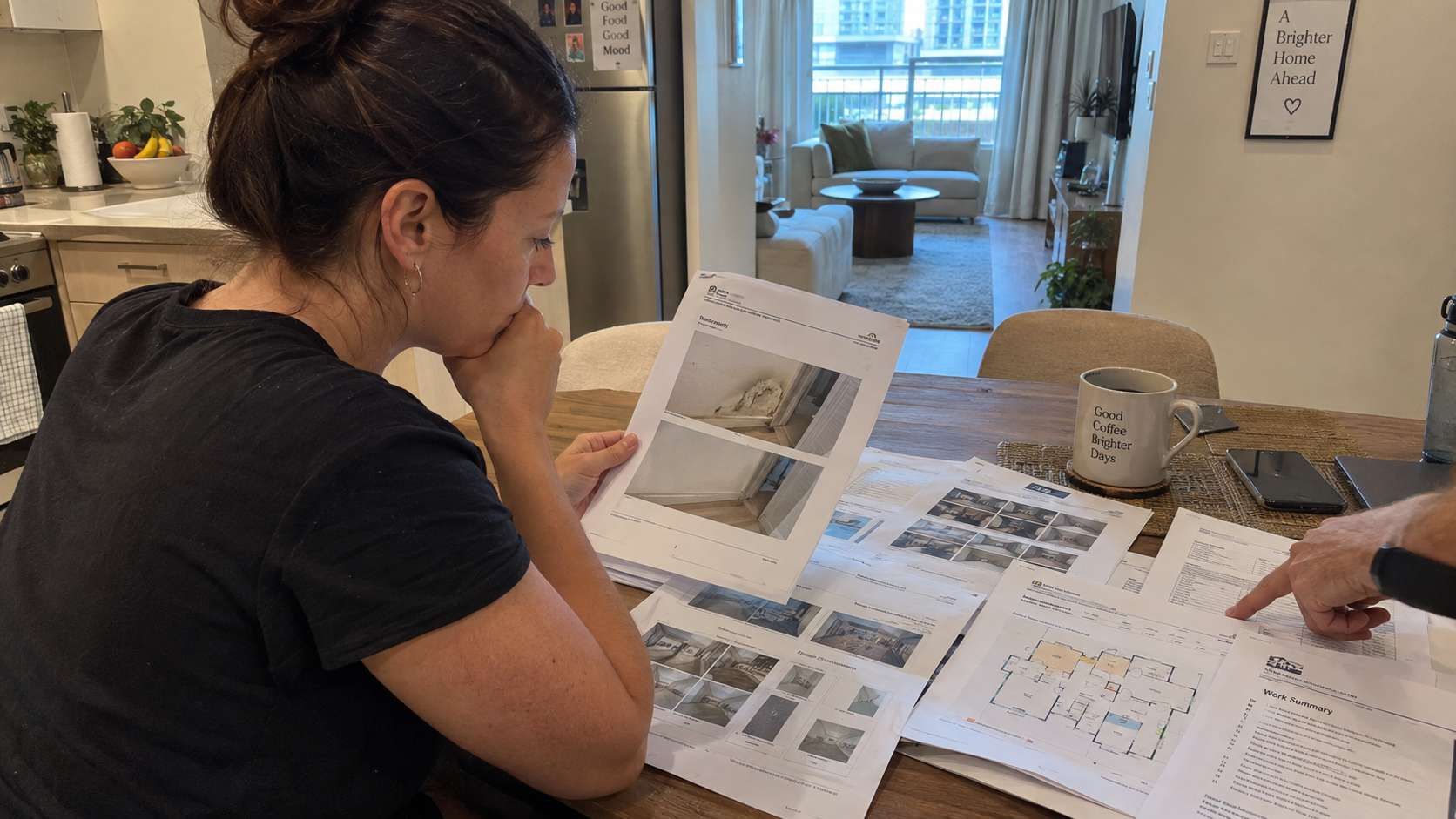 Homebuyer reviewing mold remediation reports and property restoration records at a table.