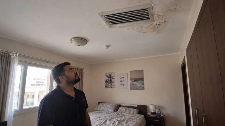 Condensation forming around an AC ceiling vent with early moisture staining and mold nearby.