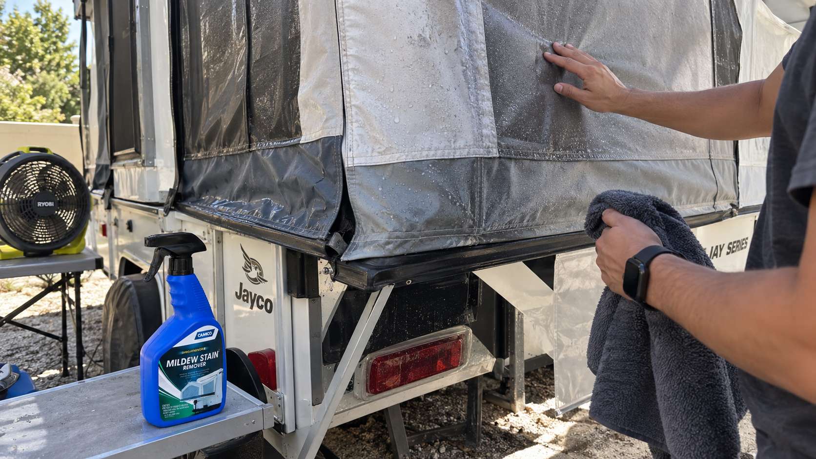 RV owner checking damp camper canvas before folding it for storage.