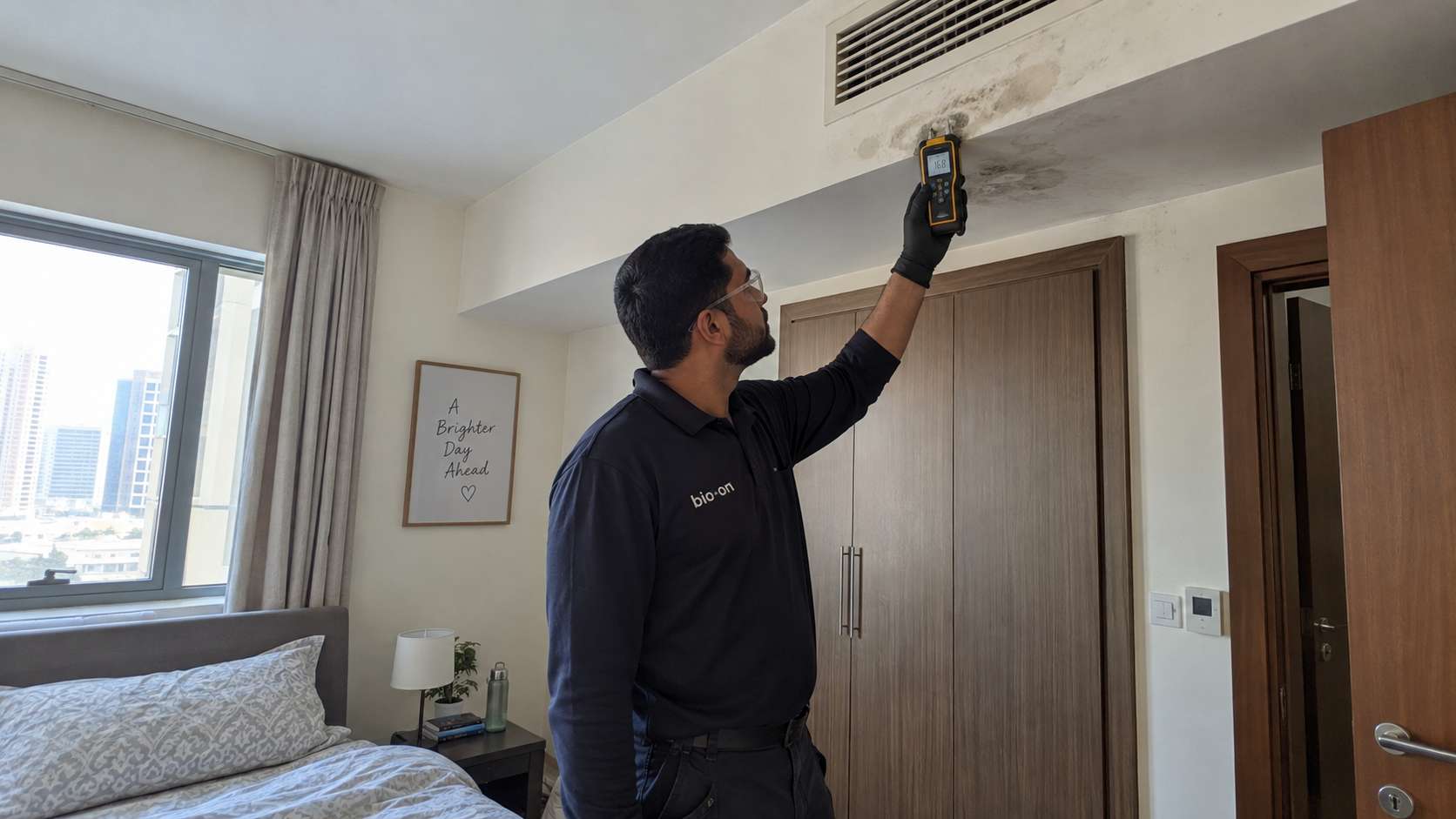 Bio-On technician checking moisture around a stained ceiling AC vent in a UAE apartment.