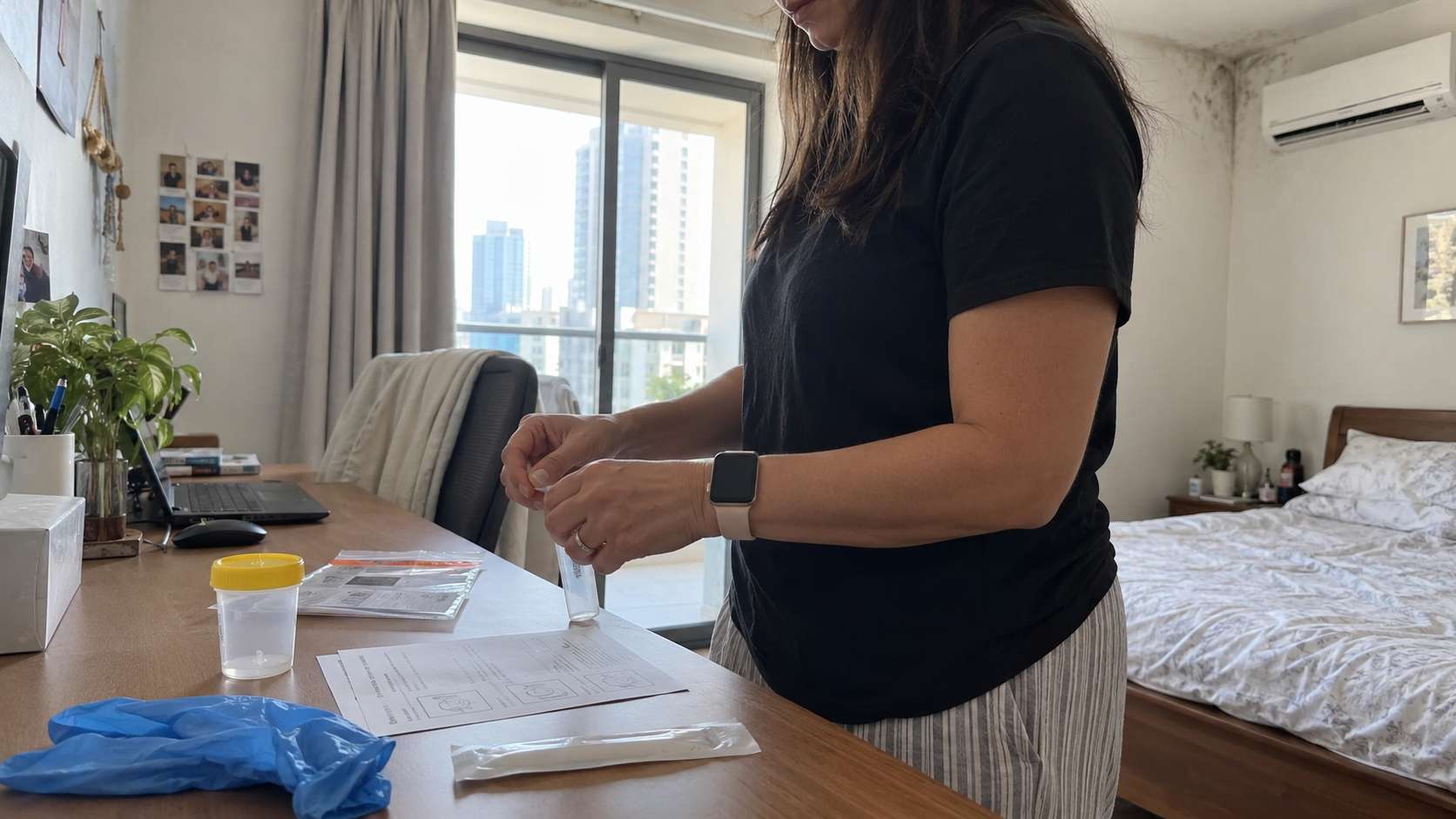 Home urine collection kit prepared in a UAE apartment with a subtle damp AC-related wall condition in the background.