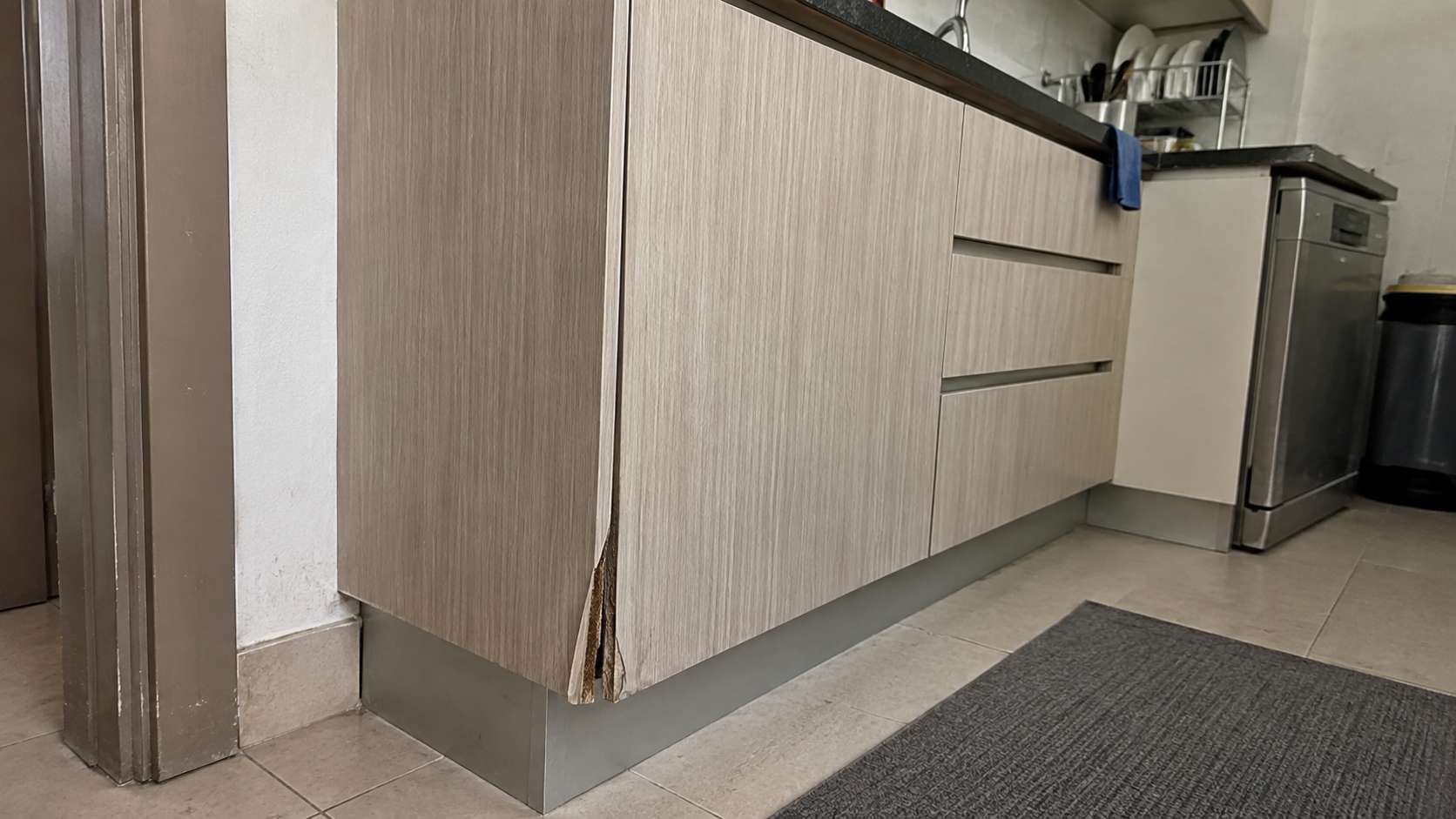 HPL cabinet with minor moisture damage and swelling at a poorly sealed lower edge.