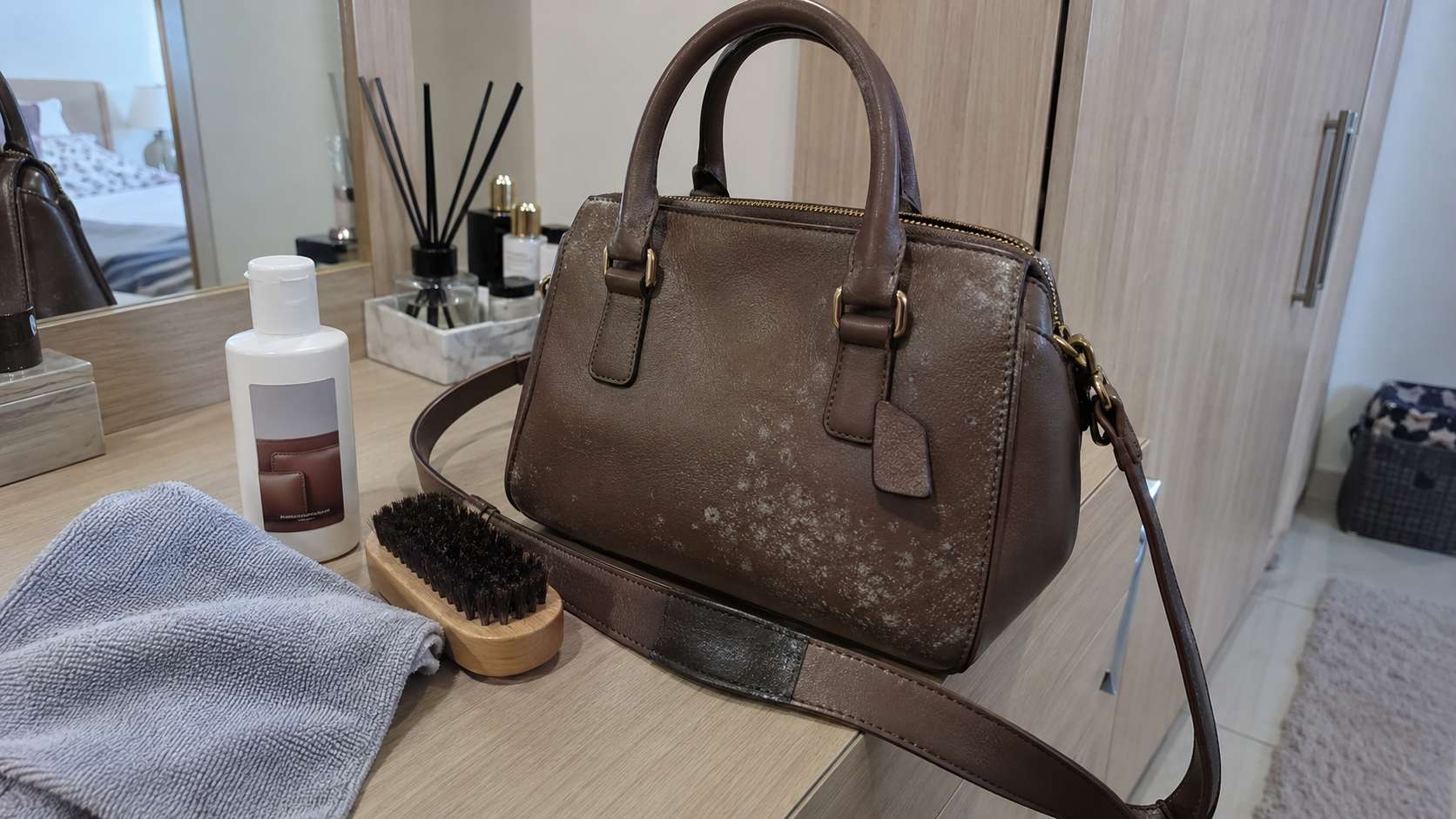 Leather handbag with light mold and a small hidden-area cleaner spot test before full treatment